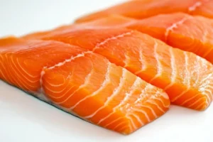 Is steelhead trout better for you than salmon? 2 Close-up of raw salmon fillets on a white surface.