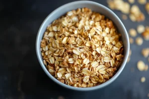 easy apple crisp recipe without oats 3 A bowl filled with golden rolled oats, placed on a dark background.