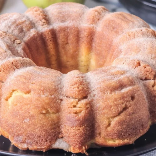 Moist Apple Cider Donut Cake topped with cinnamon sugar, perfect for fall treats.