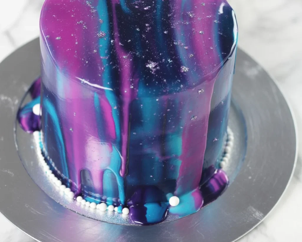 Colorful Galaxy Mirror Glaze Cake with a shiny, reflective surface, resembling outer space.