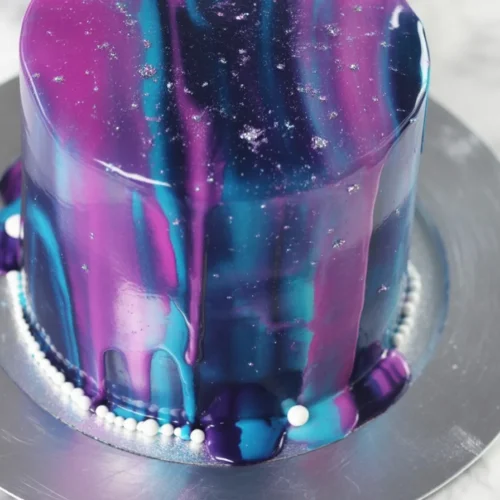 Colorful Galaxy Mirror Glaze Cake with a shiny, reflective surface, resembling outer space.