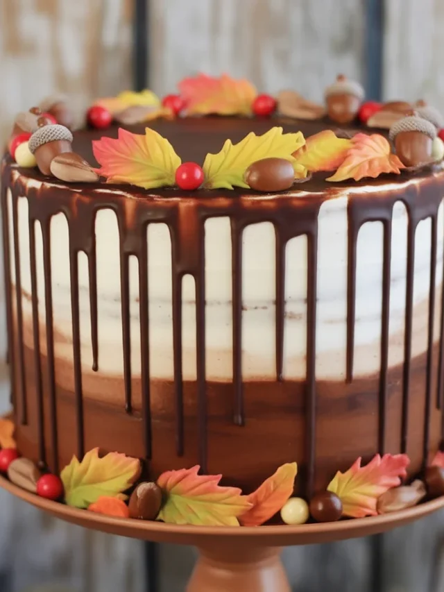 A beautifully decorated fall cake with pumpkins, flowers, and autumn-themed elements.