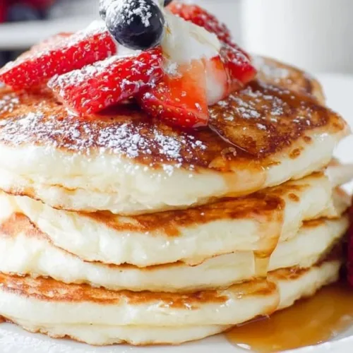 Fluffy Greek yogurt pancakes stacked on a plate with fresh fruit
