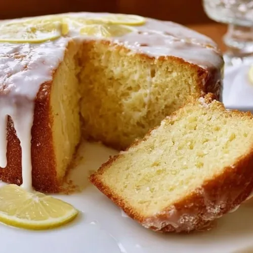 Delicious lemon pound cake slice on a plate with a lemon garnish