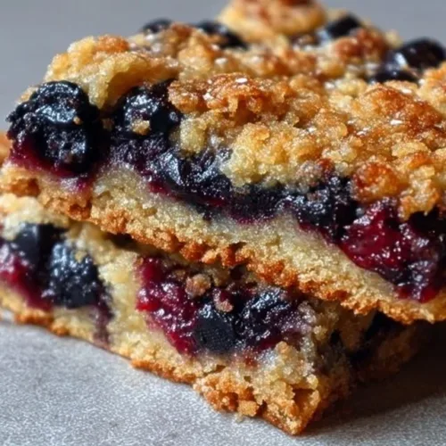 Freshly baked sourdough blueberry breakfast bars on a wooden table
