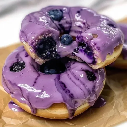 Baked blueberry cake donuts with a delicious glaze on a white plate
