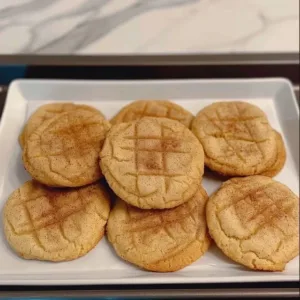 Fluffy sourdough snickerdoodles on a baking tray, sprinkled with cinnamon sugar.
