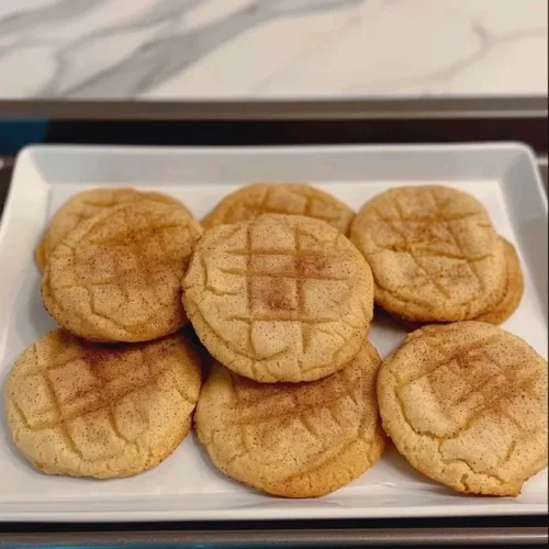 Fluffy sourdough snickerdoodles on a baking tray, sprinkled with cinnamon sugar.