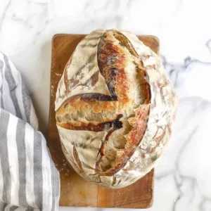 A loaf of freshly baked sourdough with beautifully scored patterns on the crust.