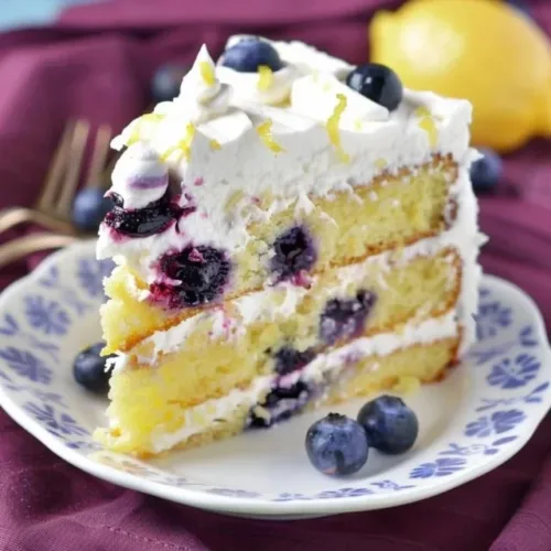 Delicious lemon blueberry cake topped with fresh blueberries and lemon zest.