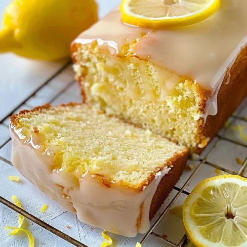 Slice of Greek yogurt lemon cake with a fresh lemon garnish