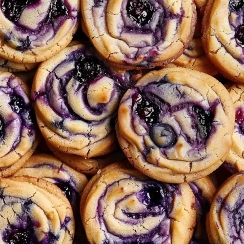 Blueberry cheesecake cookies with creamy filling and blueberry topping.