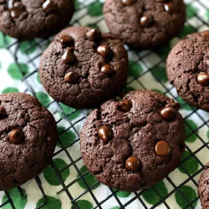 Fudgy gluten-free chocolate cookies on a cooling rack.