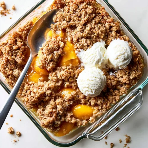 Delicious homemade Peach Crisp served in a bowl with a scoop of ice cream