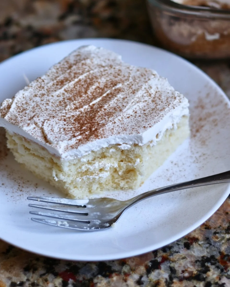 Slice of Tres Leches Sourdough Cake on a plate with milk drizzle